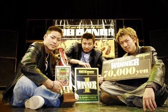 3人がトロフィーや「WINNER」と書かれたボードを持っている
